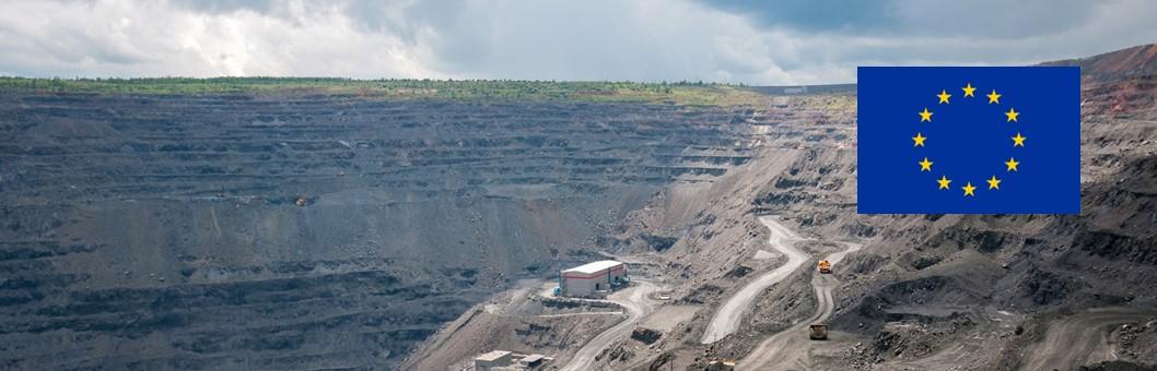 heavy dump trucks, excavators, diggers and locomotives extracting iron ore in deep quarry